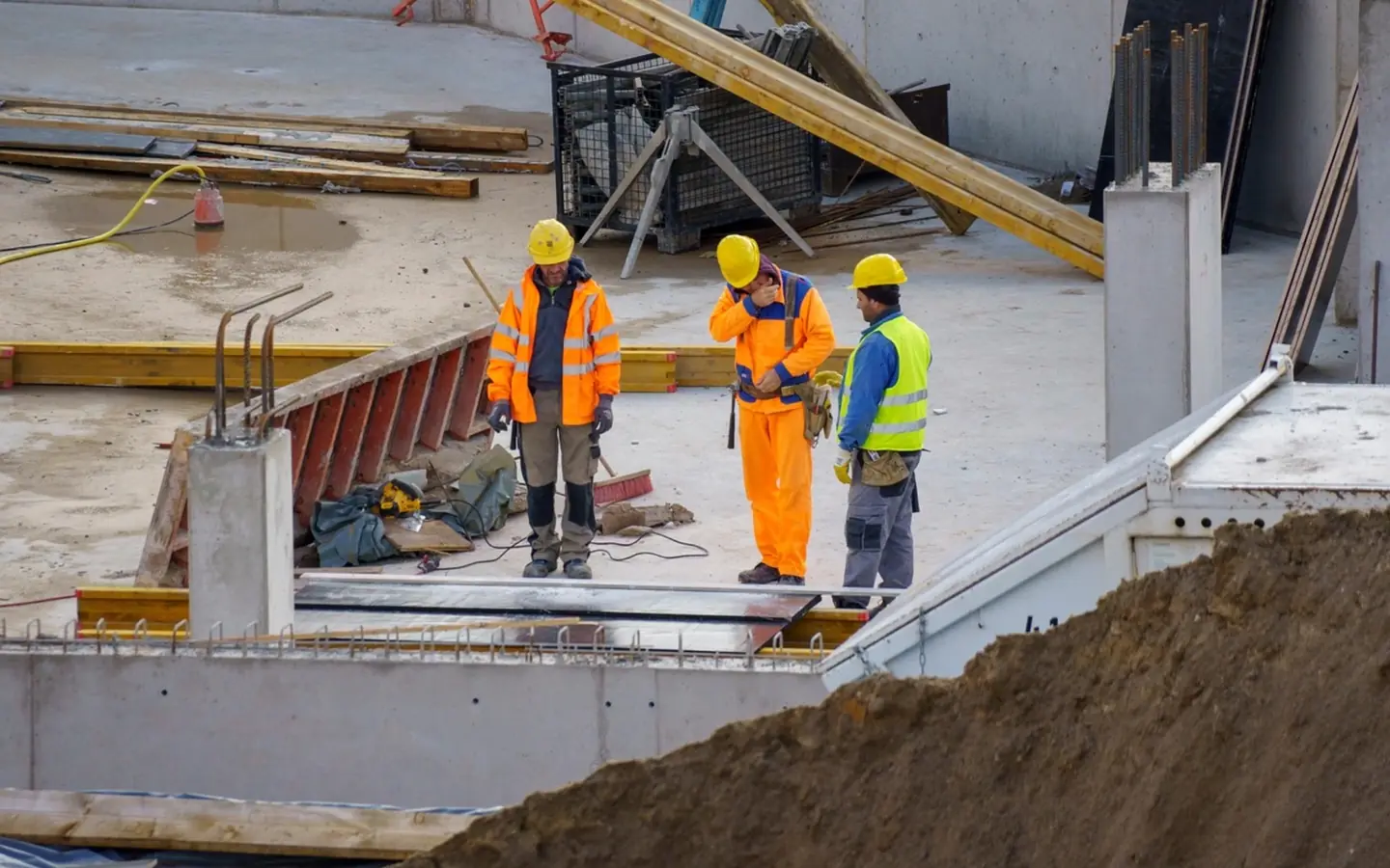 Site crew in hi-vis and hard hats on a concrete deck