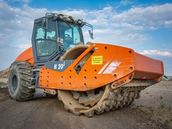 Orange road roller on a construction site