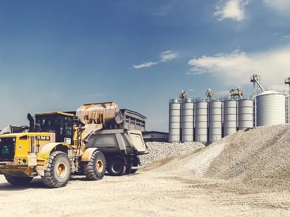 Wheel loader working beside aggregate silos