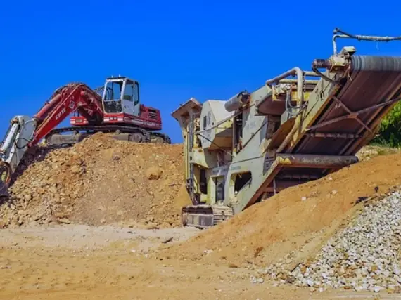 Excavator and mobile crusher at a gravel pit