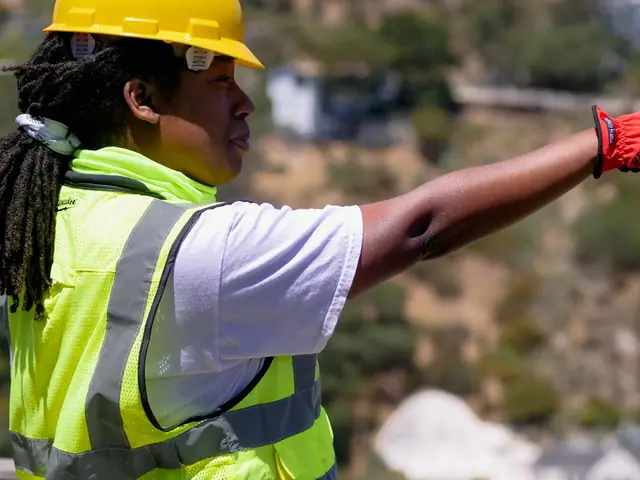 Supervisor in a hi-vis vest and work gloves directing the crew