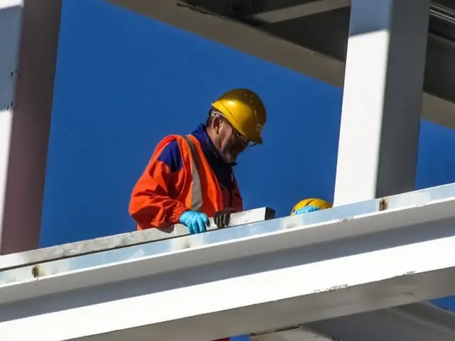 Steel erector in a hard hat working on a structural frame