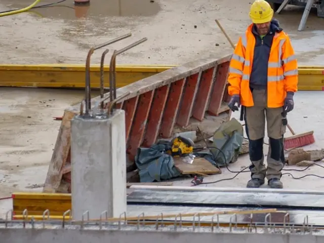 Site crew in full PPE: hard hats, hi-vis clothing and safety boots