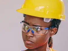 Worker wearing clear safety glasses under a yellow hard hat