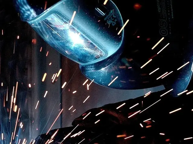 MIG welding torch at work with a shower of sparks